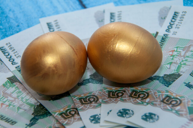 Golden chicken eggs on the background of banknotes